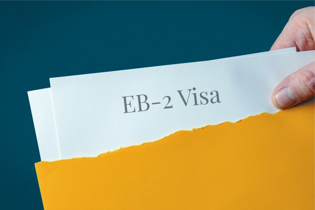 EB-2 Visa. Hand opens envelope and takes out documents. Post letter labeled with text